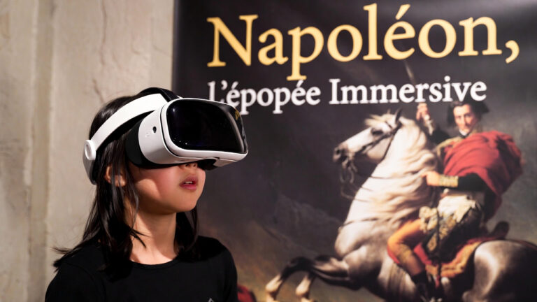 Une fille portant un casque VR avec à l'arrière-plan le poster de Napoléon, l'Epopée VR